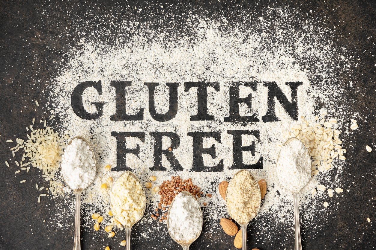 Gluten free written in flour on vintage baking sheet and spoons of various gluten free flour (almond flour, buckwheat flour, rice flour, corn flour, oatmeal flour), gluten free baking concept